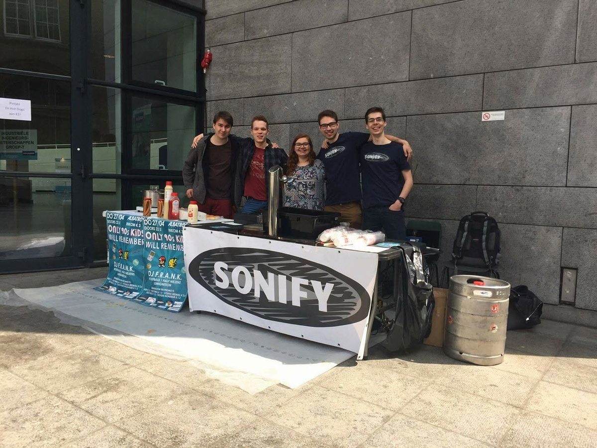 Vijf leden van het Sonify-team aan hun promostand met hotdogs, een tap en een vat
